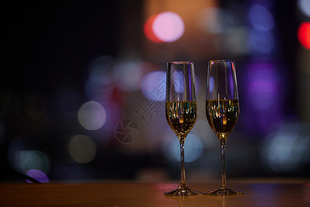 商务酒吧夜晚桌子上摆放的香槟杯背景