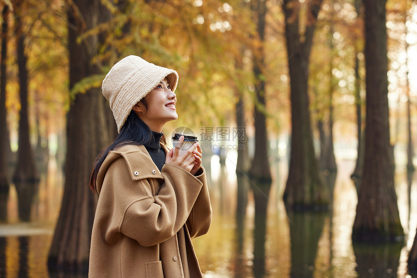 秋季户外美女手捧奶茶看风景图片