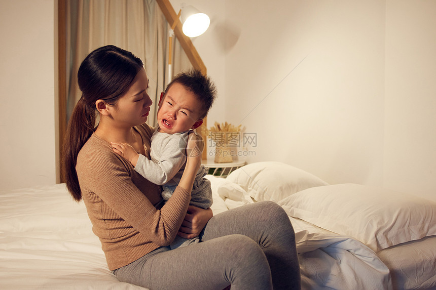 年轻宝妈安抚哭泣的婴儿图片