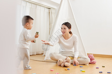 年轻母亲在家陪孩子玩耍呵护高清图片素材
