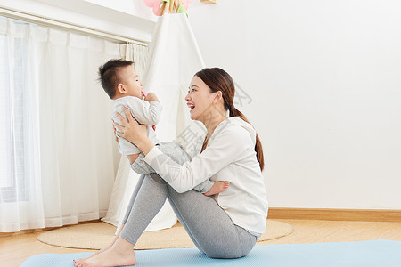 瑜伽宝宝在瑜伽垫上和宝宝互动玩耍的母亲背景