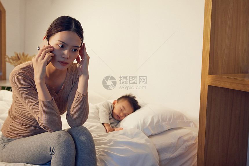 孩子睡着后情绪烦躁打电话的妈妈图片