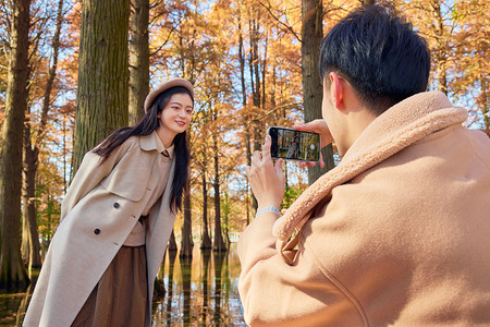 秋冬公园男生给女友拍照图片
