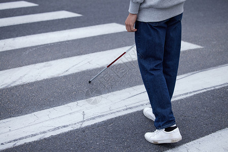 视盲青年使用盲杖探路过马路特写图片