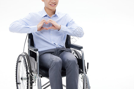 残疾人爱心坐轮椅的商务人士比爱心手势背景