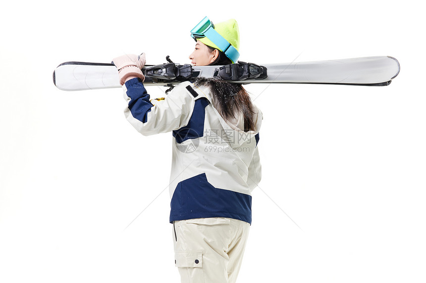 年轻美女抗着滑雪板背影图片