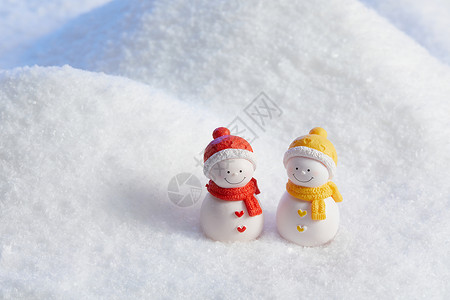 白色圣诞背景雪中的一对小雪人背景