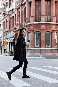 街头时尚年轻女性手拿咖啡背景图片
