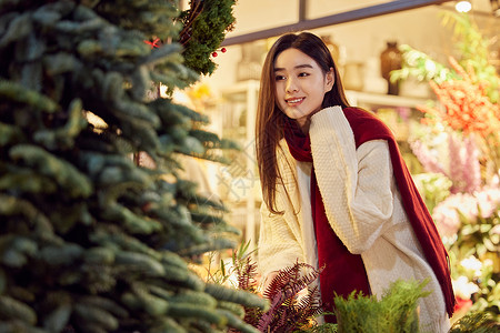 在圣诞集市采购圣诞装饰的青年女性背景图片