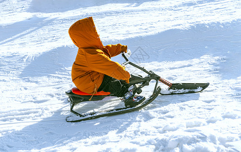 玩雪儿童雪地里玩雪橇的小男孩背景