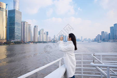 浦江游轮船上拍照打卡的旅游女生图片