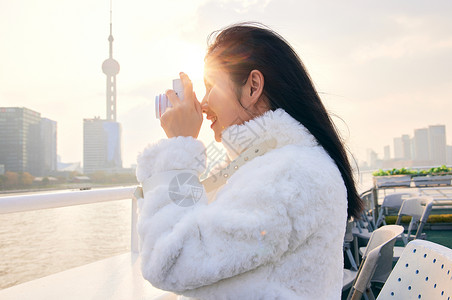 阳光灿烂女生游轮上拿着相机拍照的女生背景