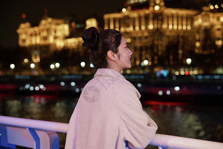 夜晚在游轮船上欣赏景色的女生冬季服饰高清图片素材