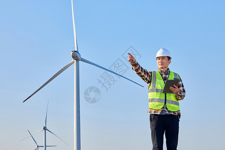 男性工程师检查环保风力发电设备图片