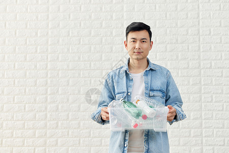 男性拿着塑料瓶回收再利用背景图片