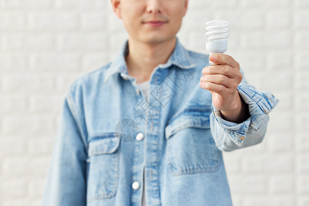 中年男性手拿电灯泡特写图片