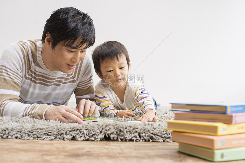 爸爸陪儿子在地毯上玩耍图片