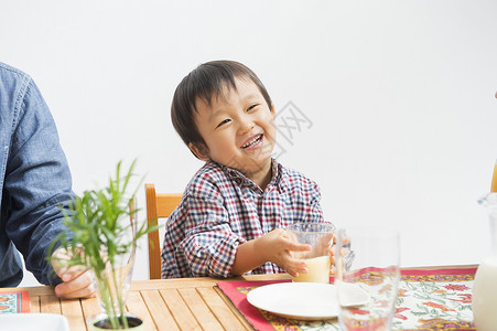 餐桌上微笑的小男孩茶高清图片素材