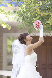 穿婚纱的幸福女人扔花束图片