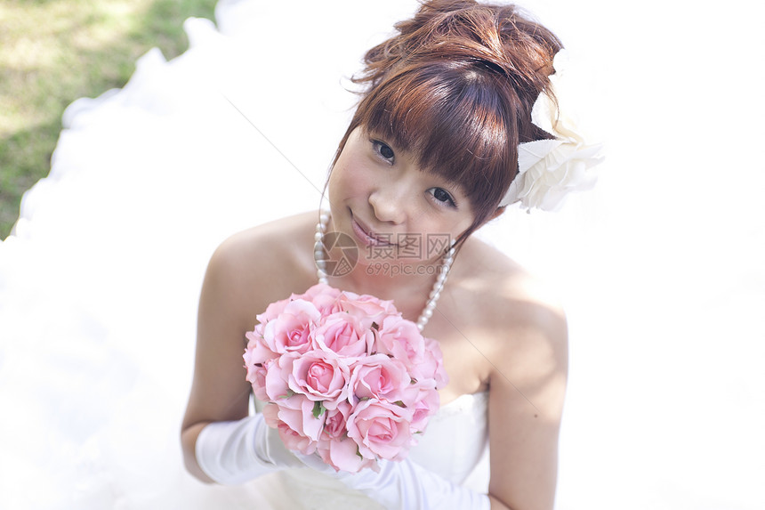 手拿玫瑰花的幸福新娘形象图片