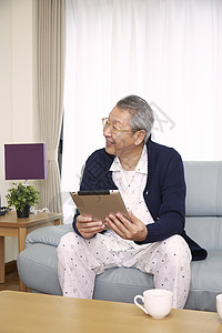 客厅里看平板电脑的老年人图片