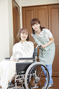 护理护工照顾轮椅上的老年人图片