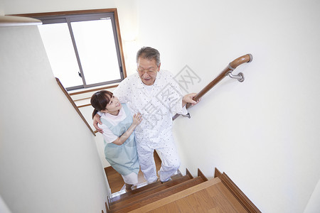护工搀扶独居老人上楼梯图片