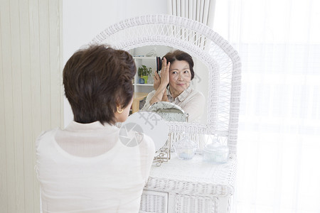 老年女性镜子前梳妆医学美容高清图片素材