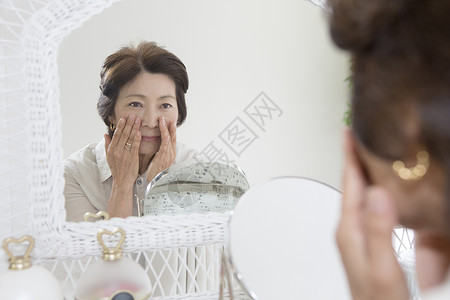 老年女性镜子前查看皱纹能源高清图片素材