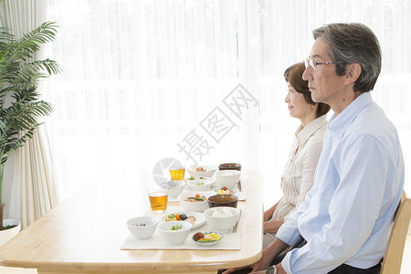 餐桌上准备就餐的中年夫妇图片