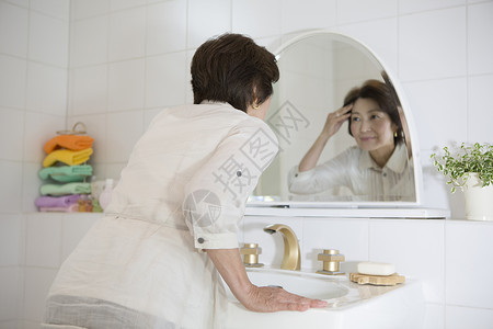 中年女性在照镜子化妆能量高清图片素材
