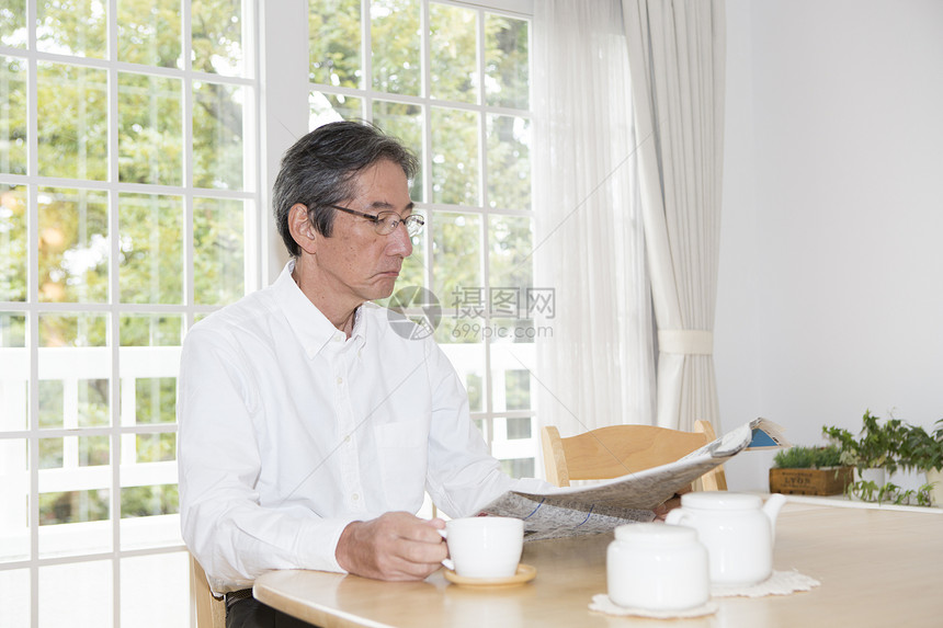 喝咖啡看报纸的老年男性图片