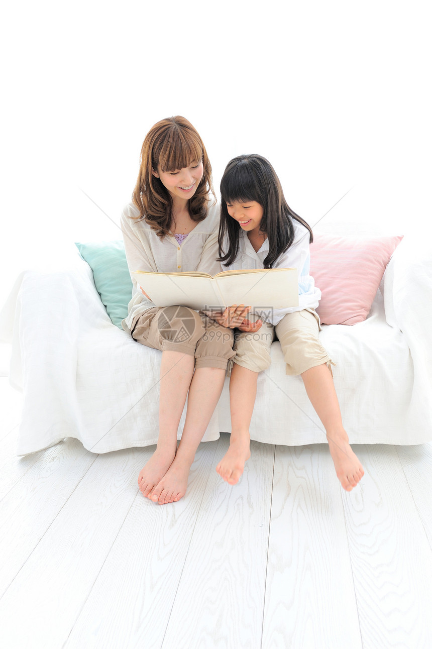 小女孩和母亲在沙发上看书图片