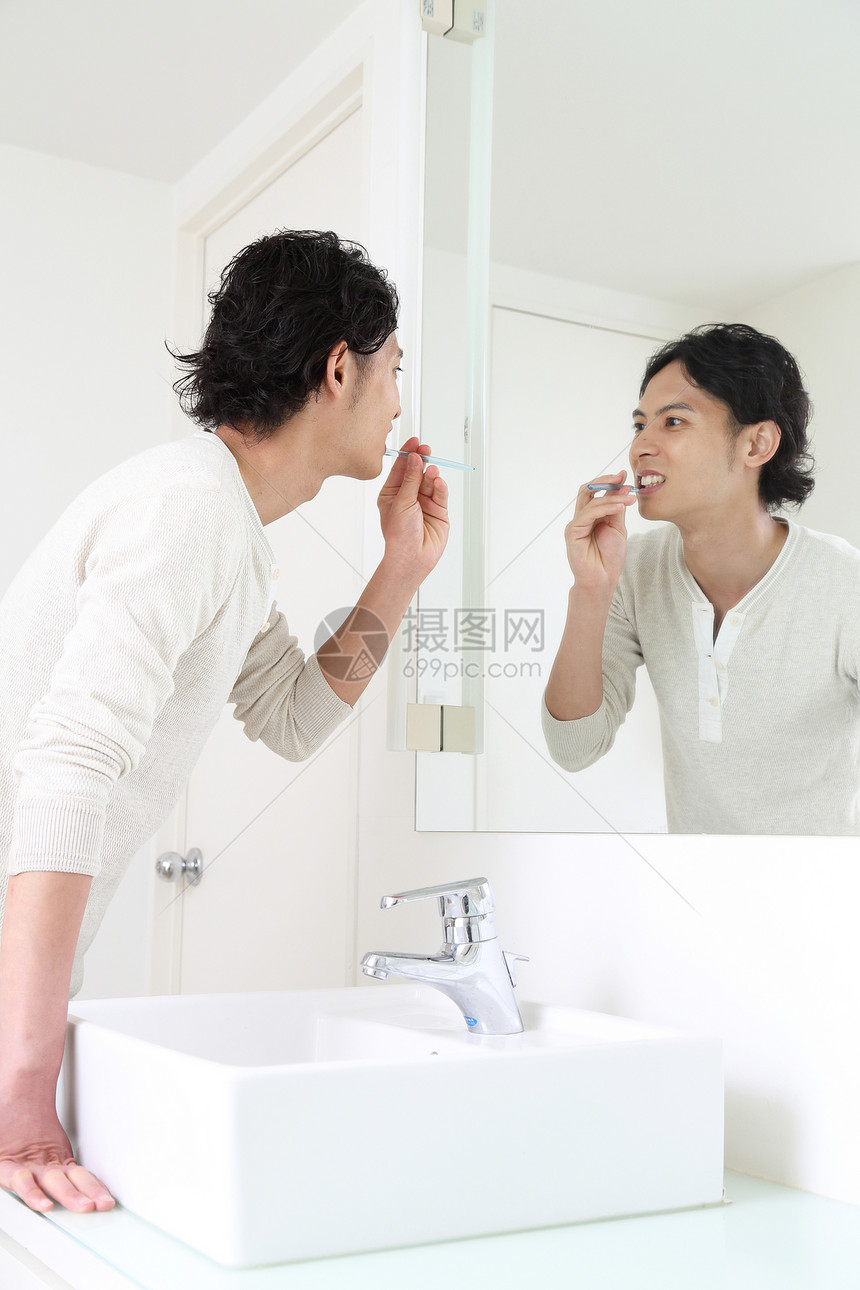 男人在对着镜子刷牙图片