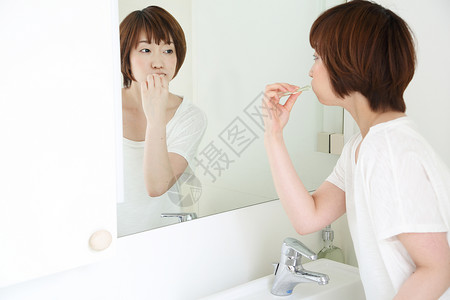 女人在对着镜子刷牙图片