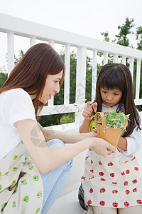 小女孩和母亲在给植物浇水图片
