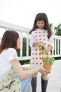 小女孩在户外给植物浇水图片