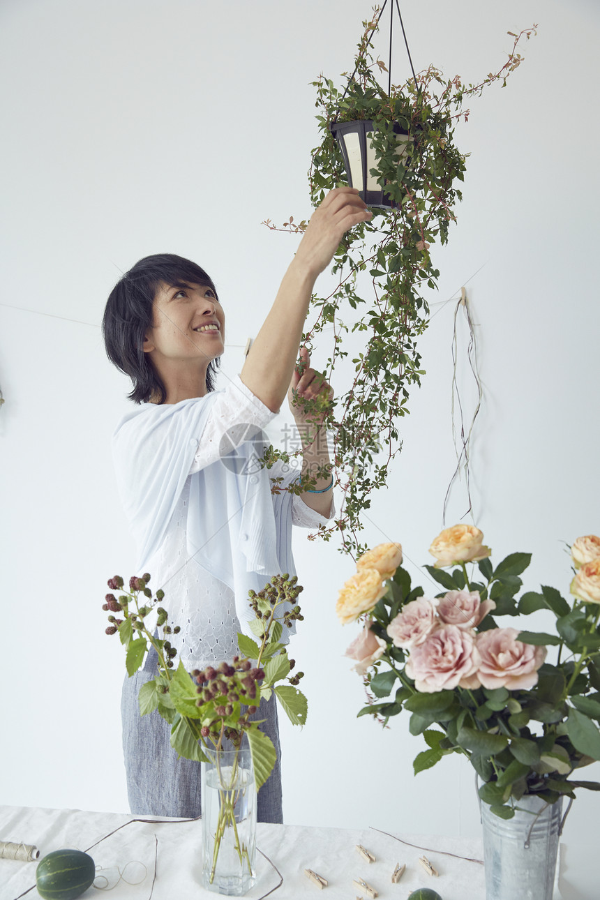 修剪鲜花布置花艺的妇女图片