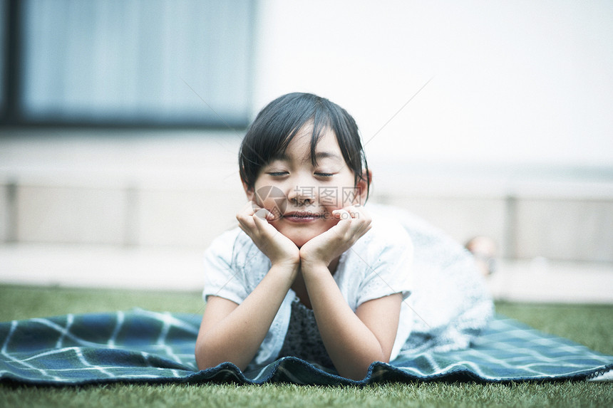 小女孩躺在花园草地上图片