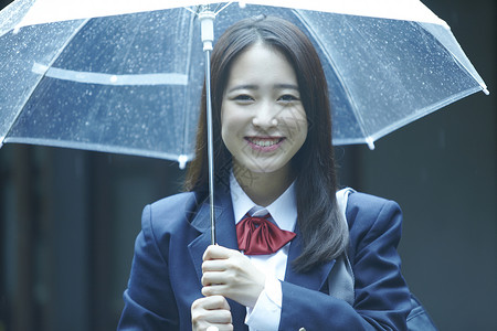 雨天撑伞上学的女高中生年轻高清图片素材