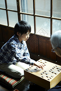 和他的祖父下棋的男孩图片