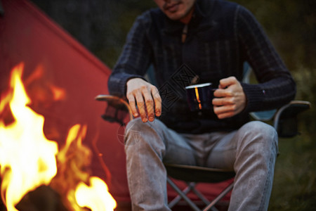 篝火边露营喝咖啡的男人图片