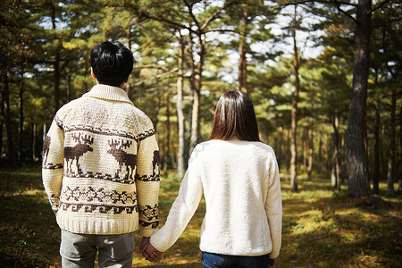 一对夫妇漫步在森林的背影图片