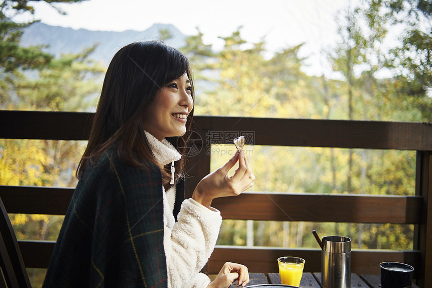 在户外露台吃早餐的女性图片