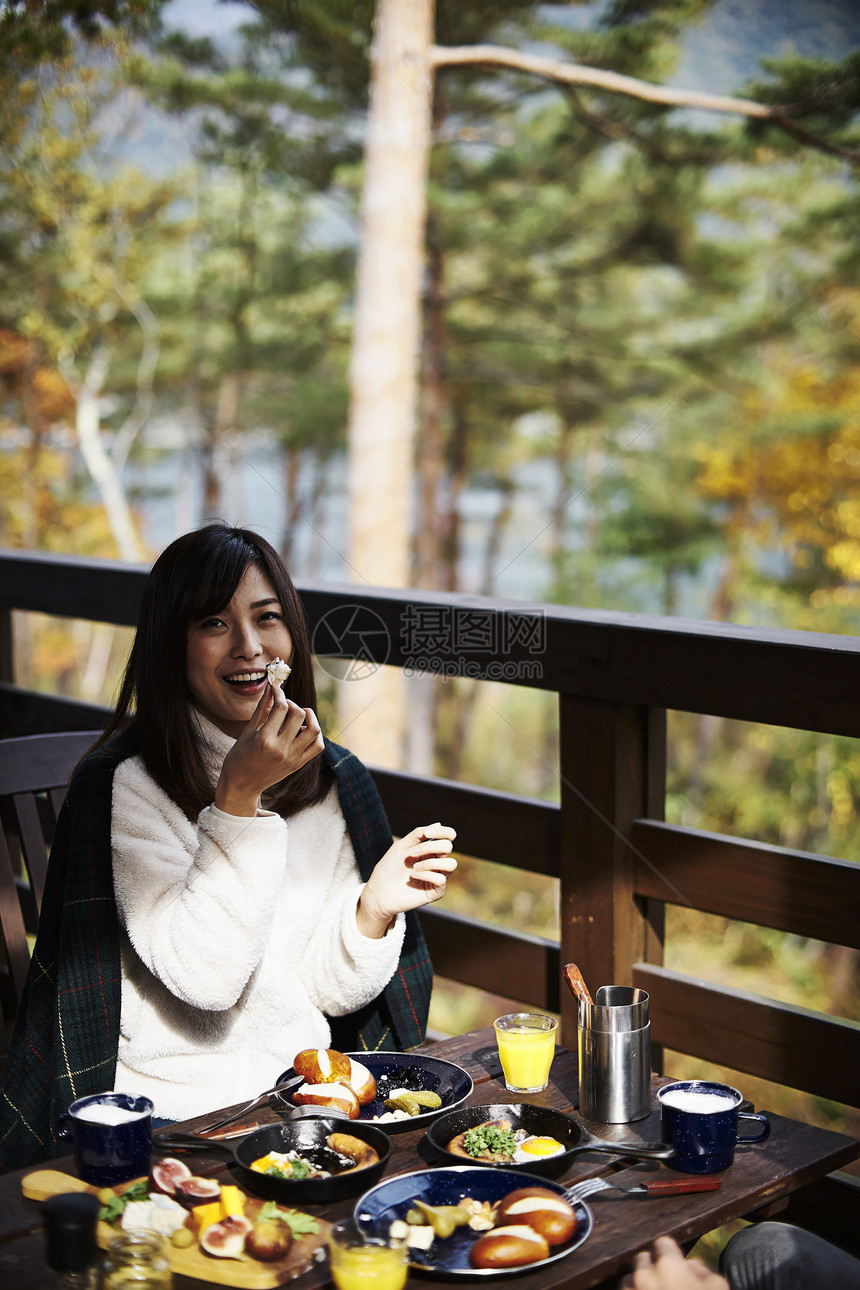 户外吃早餐的妇女图片