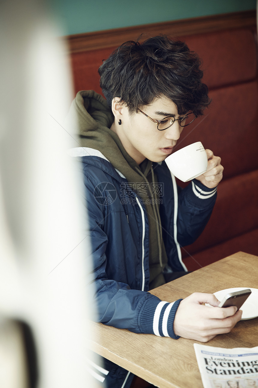 在咖啡馆喝咖啡的男性图片