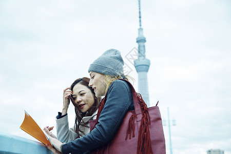 女性和外国友人看旅行地图好朋友高清图片素材