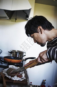 在夹起食物的男性图片