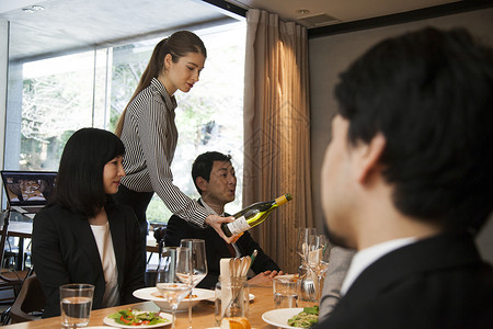 女服务员在给顾客倒酒餐厅高清图片素材