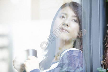 靠着窗喝咖啡的女生图片